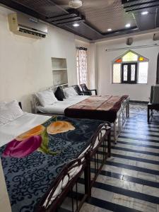 a room with three beds and a window at Hotel New Sun and Rock in Mount Ābu