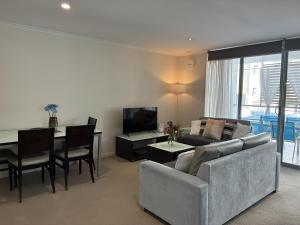 a living room with a couch and a table at Merivale stay in South Brisbane two beds two baths one parking in Brisbane