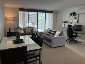 a living room with a couch and a table at Merivale stay in South Brisbane two beds two baths one parking in Brisbane
