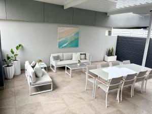 ein Wohnzimmer mit einem weißen Tisch und Stühlen in der Unterkunft Simplicity Terrigal in Terrigal