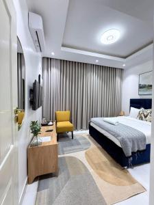 a hotel room with a bed and a yellow chair at Tranquil Ridge BnB in Blantyre