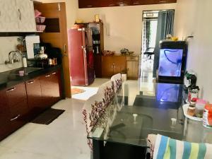 a kitchen with a glass table and some chairs at Vishnoo Stays Lush Green Room in Atal Nagar in Nawāgaon +7 photos