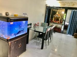 a dining room with a fish tank and a table at Vishnoo Stays Lush Green Room in Atal Nagar in Nawāgaon
