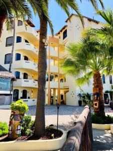 a large building with palm trees in front of it at Vista Hermosa Resort and Spa in Rosarito