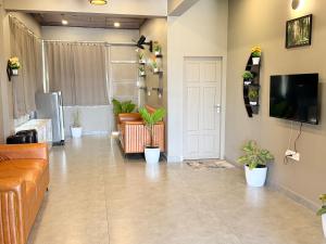 a living room with a couch and potted plants at Valensa lake view in Kalpetta
