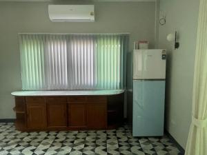 a kitchen with a refrigerator next to a window at Butterfly Home Mai Khao Phuket in Ban Suan Maphrao