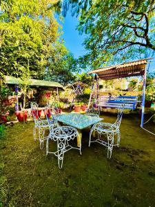a table and chairs in a yard with a swing at Hotel New Sun and Rock in Mount Ābu