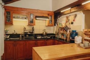 a kitchen with wooden cabinets and a counter top at Patan Hideaway in Pātan +11 photos