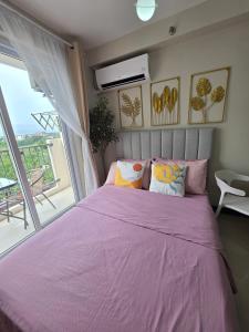 a pink bed in a room with a large window at Saekyung Lapu-lapu in Suba +38 photos