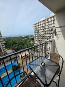 a balcony with a table and chairs and a pool at Saekyung Lapu-lapu in Suba