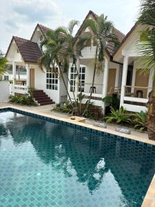 a house with a swimming pool in front of a house at Penn house with shared pool in Ko Raeng