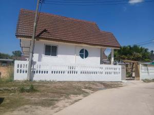 a white house with a white picket fence at Penn house with shared pool in Ko Raeng