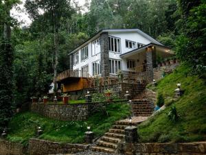 a large white house on a hill with stairs at VOX Vanam Bungalow in Kodaikānāl
