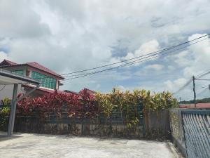 a fence in front of a house with palm trees at Seri Mersing Villa A in Mersing
