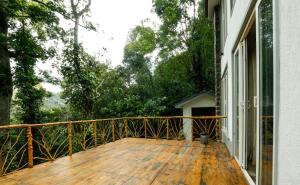 a porch with a wooden deck with a cat on it at VOX Vanam Bungalow in Kodaikānāl