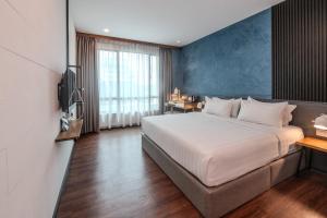 a bedroom with a large bed with a blue wall at O&G Hotel Parit Buntar in Parit Buntar +50 photos