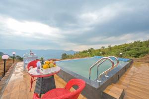 a patio with a table and chairs next to a swimming pool at Lifeline Villas - Horizon Backwater Luxe Infinity Pool Villa in Mahabaleshwar