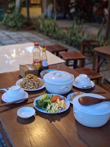 a table with plates of food and bowls of food at Muong Dinh Lodge in Ấp Nhơn Bình +90 photos
