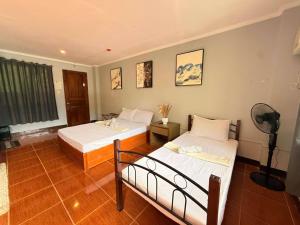 a bedroom with two beds and a fan at Chad's Lodge in Coron +22 photos