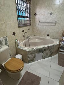 a bathroom with a tub and a toilet and a sink at Executive en-Suite - Southgate in Southgate