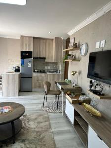 a living room with a kitchen with a television at Executive en-Suite - Southgate in Southgate