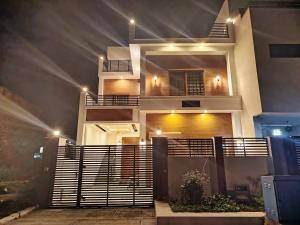 a house with lights on the side of it at The Warmer House Islamabad Airport in Islamabad