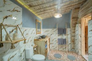 a bathroom with a toilet and a wooden ceiling at Ratna's Green Hill Penida by Bali Cabin in Nusa Penida +56 photos