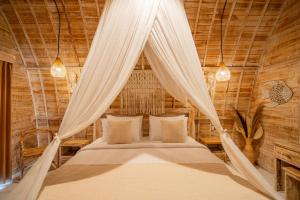 a bedroom with a bed with a mosquito net at Ratna's Green Hill Penida by Bali Cabin in Nusa Penida