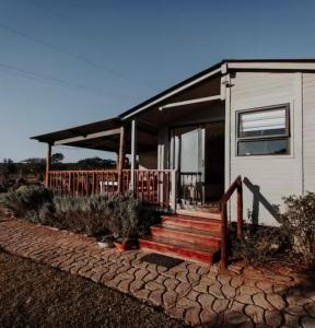 a home with a porch and stairs to it at Chilli cottage - off grid get away in Mkondeni