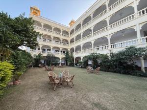 a large building with chairs and a table in the courtyard at Atulya Niwas - Aravali views in Udaipur