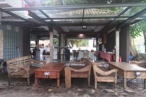 a patio with wooden tables and chairs under a pergola at Dermaga Resort Pramuka in Pulau Pramuka