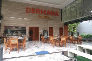 a restaurant with wooden tables and chairs in front of it at Dermaga Resort Pramuka in Pulau Pramuka