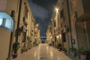 an empty alley way at night with lights at Xefan Hotels in Karachi