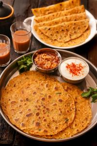 a table with three plates of naan bread and dip at Hotel New Sun and Rock in Mount Ābu +13 photos