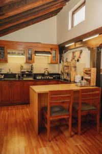 a kitchen with wooden cabinets and a wooden table at Patan Hideaway in Pātan