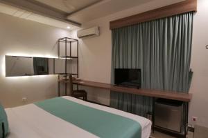 a hotel room with a bed and a television at Xefan Hotels in Karachi