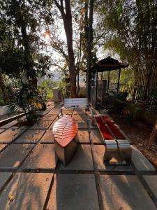 an umbrella and a bench on a sidewalk at Pomma Holidays and Resorts in Muthanga