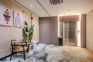 an empty room with a chair and a refrigerator at O&G Hotel Parit Buntar in Parit Buntar