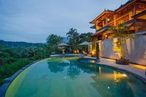 a swimming pool in front of a house at Villa Karma Loka in Sidemen