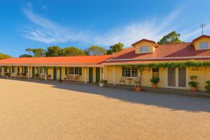 a large yellow building with a red roof at MOTEL ROYAL TARA in Binalong