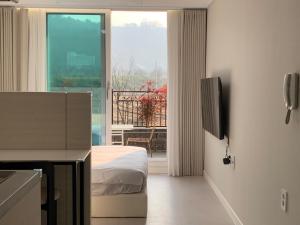 a bedroom with a bed and a large window at Two Rest Pension in Damyang
