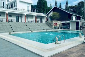 a swimming pool in front of a house at Alfa Jivana Resort in Sampal 2