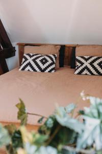 a bed with black and white pillows on it at Big loft 100m from beach in Scheveningen