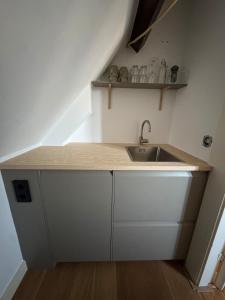 a small kitchen with a sink and a shelf at Big loft 100m from beach in Scheveningen +21 photos