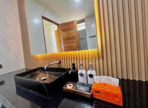 a bathroom with a black sink and a mirror at บ้านเคียงสะหวัน in Muang Phaluka +17 photos