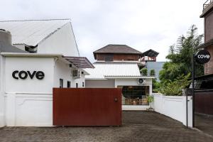 a white building with a gate in front of it at Cove Chara in Jimbaran