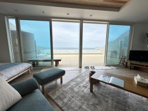 a living room with a view of the beach at Lapita Resort in Sakai