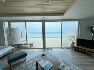 a living room with a view of the beach at Lapita Resort in Sakai