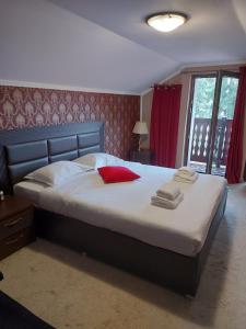 a bedroom with a large bed with towels on it at Platinvm B&B in Predeal
