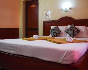 a bedroom with a bed with two pillows on it at amb guest house in Chennai